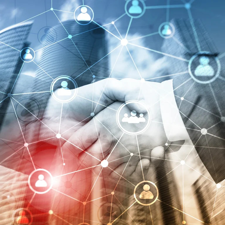 A handshake in front of a financial district backdrop with faded diagrams of people